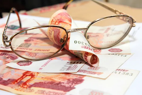 Heap soft money and old spectacles — Stock Photo, Image