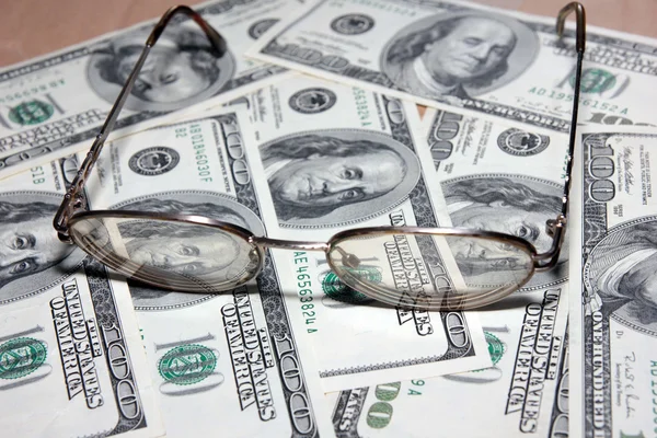 Sterty miękkich pieniądze i stare okulary — Zdjęcie stockowe