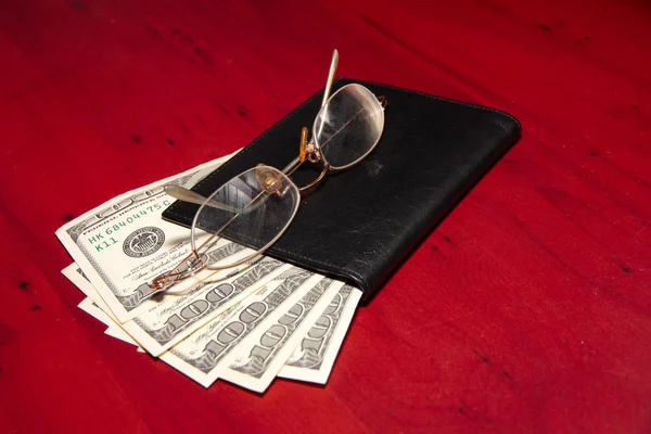 Handväska, gamla glasögon och dollar — Stockfoto