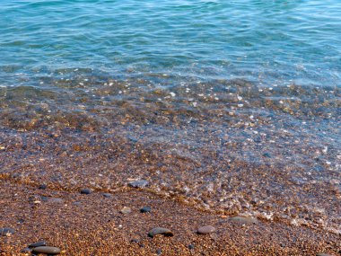 Şeffaf deniz dalgaları ve kumlu plajlar.