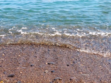 Şeffaf deniz dalgaları ve kumlu plajlar.