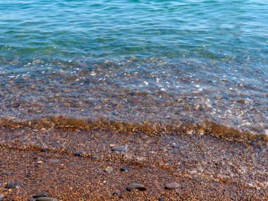 Şeffaf deniz dalgaları ve kumlu plajlar.