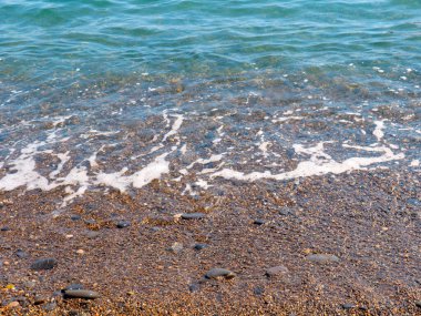 Şeffaf deniz dalgaları ve kumlu plajlar.