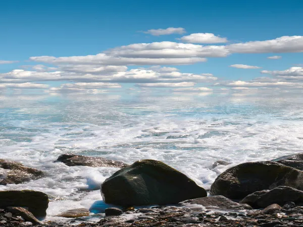 美しい海の小石のビーチと晴れ曇りの空 ストック写真