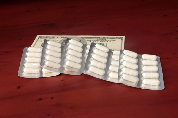 Dollars en medische pillen — Stockfoto