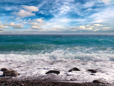 Güzel dalgalar ve bulutlu gökyüzünün arka planında deniz plajı