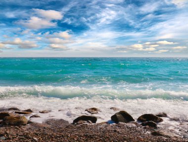 Güzel dalgalar ve bulutlu gökyüzünün arka planında deniz plajı