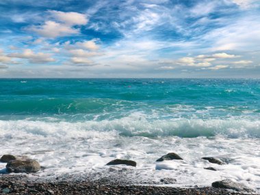 Dalgalı ve çakıl taşı plajlı güzel deniz manzarası