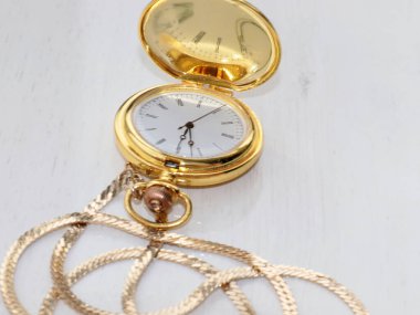 Değerli metal altından yapılmış bir çantada güzel antika bir cep saati.