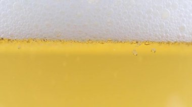 Kalın köpüklü bir bira bardağında oksijen kabarcıkları.