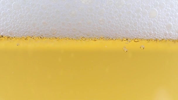一杯淡啤酒上浓密泡沫中的氧气泡 — 图库视频影像