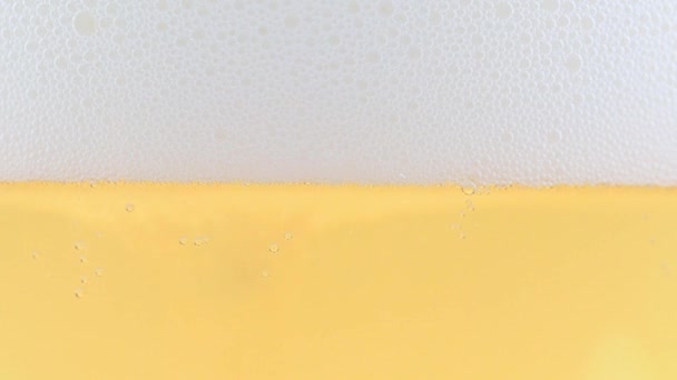 一杯淡啤酒和表面泡沫中的气泡 — 图库视频影像