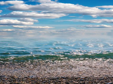 Aktif eğlence için güzel çakıl taşı plajı ve deniz dalgaları