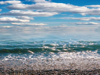 Aktif eğlence için güzel çakıl taşı plajı ve deniz dalgaları
