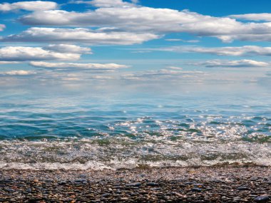 Aktif eğlence için güzel çakıl taşı plajı ve deniz dalgaları