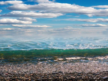 Aktif eğlence için güzel çakıl taşı plajı ve deniz dalgaları