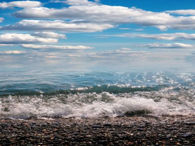 Aktif eğlence için güzel çakıl taşı plajı ve deniz dalgaları