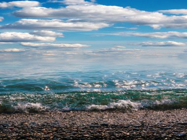 Aktif eğlence için güzel çakıl taşı plajı ve deniz dalgaları