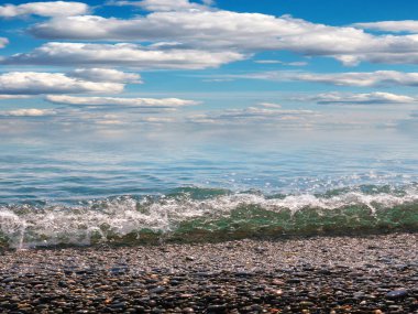 Aktif eğlence için güzel çakıl taşı plajı ve deniz dalgaları
