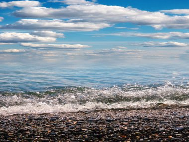 Aktif eğlence için güzel çakıl taşı plajı ve deniz dalgaları