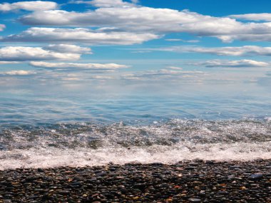 Aktif eğlence için güzel çakıl taşı plajı ve deniz dalgaları