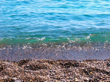 Güzel deniz dalgaları çakıl taşı sahilinde yuvarlanıyor.