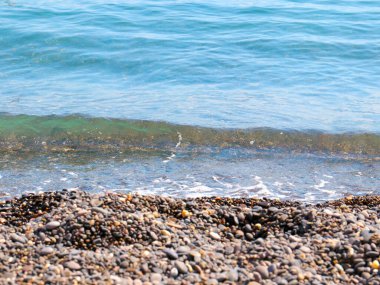 Güzel deniz dalgaları çakıl taşı sahilinde yuvarlanıyor.