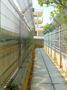 Bölge sınırında yaya yolu ve metal çitler var.