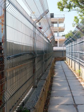 Bölge sınırında yaya yolu ve metal çitler var.