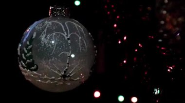 Bir çam ağacının dalında yavaş dönen Noel oyuncağı.