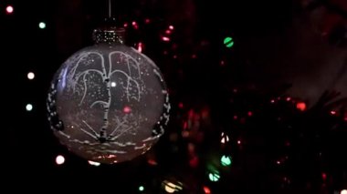 Bir çam ağacının dalında yavaş dönen Noel oyuncağı.