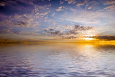 Sakin deniz suyu yüzeyindeki bulutlu gökyüzünün hoş yansıması