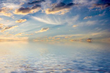 Sakin deniz suyu yüzeyindeki bulutlu gökyüzünün hoş yansıması