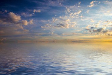 Sakin deniz suyu yüzeyindeki bulutlu gökyüzünün hoş yansıması