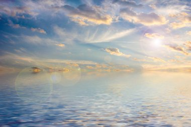 Sakin deniz suyu yüzeyindeki bulutlu gökyüzünün hoş yansıması