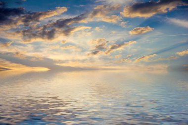 Sakin deniz suyu yüzeyindeki bulutlu gökyüzünün hoş yansıması
