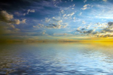 Sakin deniz suyu yüzeyindeki bulutlu gökyüzünün hoş yansıması