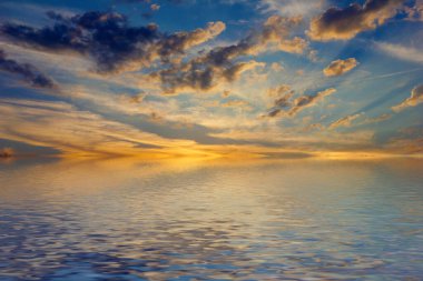 Sakin deniz suyu yüzeyindeki bulutlu gökyüzünün hoş yansıması