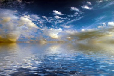 Sakin deniz suyu yüzeyindeki bulutlu gökyüzünün hoş yansıması