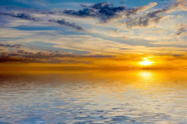 Sakin deniz suyu yüzeyindeki bulutlu gökyüzünün hoş yansıması