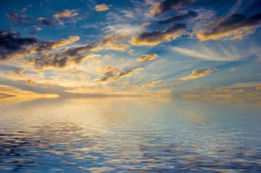 Sakin deniz suyu yüzeyindeki bulutlu gökyüzünün hoş yansıması