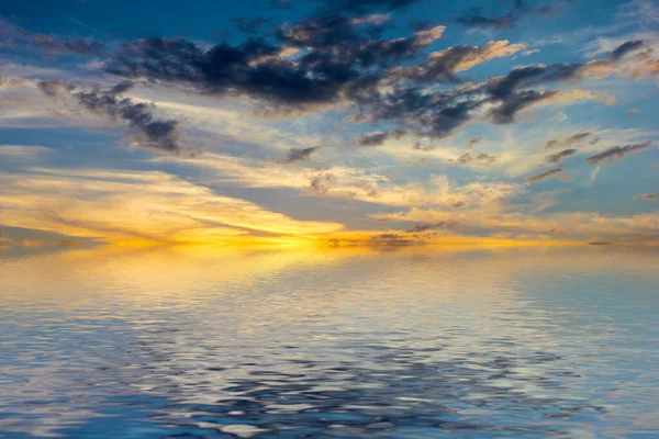 Sakin deniz suyu yüzeyindeki bulutlu gökyüzünün hoş yansıması