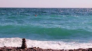 Aktif eğlence için güzel dalgalar ve çakıl taşlı deniz plajı