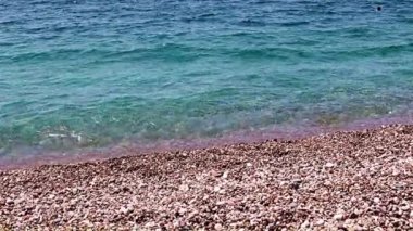 Aktif eğlence için güzel dalgalar ve çakıl taşlı deniz plajı