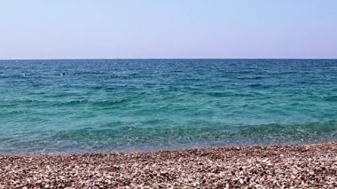 Aktif eğlence için güzel dalgalar ve çakıl taşlı deniz plajı