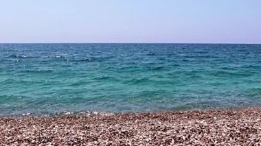 Aktif eğlence için güzel dalgalar ve çakıl taşlı deniz plajı