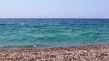 Aktif eğlence için güzel dalgalar ve çakıl taşlı deniz plajı
