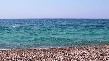 Aktif eğlence için güzel dalgalar ve çakıl taşlı deniz plajı
