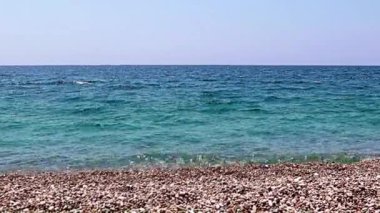 Aktif eğlence için güzel dalgalar ve çakıl taşlı deniz plajı