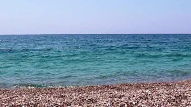 Aktif eğlence için güzel dalgalar ve çakıl taşlı deniz plajı